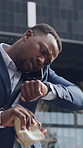 Business, late and black man in city, phone call and check time for morning commute, bagel and talking. African person, smart watch or snack in street, cellphone and app for communication and stress