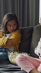 Popcorn, upset and children in home for watching tv, movie or series together on weekend. Bonding, angry and girl kids eating snack for streaming film with online subscription in living room at house
