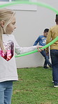 Friends, children and playing together in backyard with hula hoop, soccer match and bonding. Social group, kids and fun outdoor at house with plastic ring, football game and weekend visit on holiday