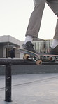 Legs, person and balance with skateboard on rail in city for trick, training and extreme sports. Skateboarder, sneakers and stunt at skatepark, exercise and hobby with grind for action outdoor