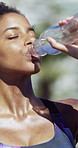 Fitness, woman and drinking water outdoor for health, wellness and smile with funny face on break. African person, exercise and athlete with bottle for hydration, nutrition and laugh with portrait