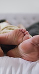 Couple, feet and intimate on bed, home and bonding with partner on anniversary, commitment and love. Sleeping, together and people on break, closeup and cuddle in bedroom, romance or relationship
