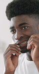 Black man, cleaning and teeth with dental floss in bathroom for bacteria or germ removal in home. Male person, reflection or grooming teeth with wire or mirror for gum, mouth or oral hygiene in house