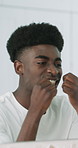 Black man, mirror or cleaning with dental floss in bathroom for bacteria or germ removal in home. Male person, reflection or grooming teeth with wire or string for gum, mouth or oral hygiene in house
