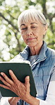 Tablet, nature and senior woman in park for social media, networking or contact on app in morning. Outdoor, digital technology and elderly female person reading online blog for retirement tips.