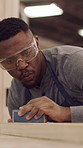 Carpentry, sanding and black man in workshop for woodworking, smooth surface and furniture. Factory, carpenter and person with sandpaper for restoration, repair and wood design for timber project