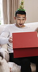 Christmas, wow and man on sofa with gift for surprise at xmas party, event and social gathering. December, friends and person with box excited for tradition, festive season and holiday with present