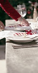 Hands, setting table and plates at Christmas for lunch, candy cane or outdoor with decoration. Person, creativity and cloth for dining, display or presentation for social event at xmas in backyard