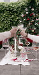 People, christmas and hands with cheers for celebration, social gathering or get together at table. Group, family or friends with glass, eggnog or toast for festive tradition or december holiday
