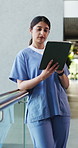 Woman, nurse and reading with tablet in hospital for research, medical report and test results. Person, typing or digital with healthcare schedule, patient history and telehealth for surgery feedback