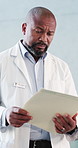 Black man, doctor and intern with folder at hospital for medical file, patient history and test results. Mature person, chart and notes for healthcare, referral letter and consent report of treatment