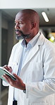 Thinking, doctor and man with tablet, hospital and medical research for illness, serious and online. Scroll, info and black person with tech for diagnosis, mature healthcare worker and reflection