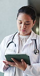 Woman, doctor and reading with tablet in hospital for research, medical report and test results. Thinking, surgeon and walk with digital for healthcare agenda, treatment planning and surgery feedback