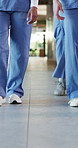 Doctor, legs and people in hospital, walking and uniform with healthcare, shoes and interns. Closeup, employees and professional in clinic, medical service and appointment with wellness and steps