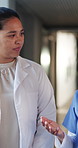 Doctor, nurse and conversation with walk in hospital for medical opinion, update or advice. Health team, people and meeting in clinic hallway with treatment feedback, surgery schedule or workflow