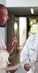 Doctors, paperwork and argument with file in hospital for medical opinion, update or advice. Health team, people and meeting in clinic hallway for treatment feedback, surgery schedule or workflow
