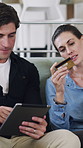 Couple, tablet and credit card on couch with online shopping, discussion and point with budget at apartment. Man, woman and fintech with banking, application or e commerce for deal on web at house