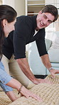 Couple, roll carpet and smile in new home with renovation, interior design and excited with real estate. Man, woman and happy with mat, partnership and bonding in living room on floor at property