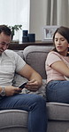 Cellphone, cheating and couple with argument on sofa in living room for divorce, affair or breakup. Phone, upset and man with woman, fighting and text for online infidelity on dating app in home