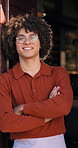 Face, man and waiter with arms crossed at cafe for welcome, friendly server and customer service. Portrait, person and confident at front door, proud employee and hospitality industry at restaurant