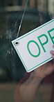 Small business, hands and open sign at restaurant window for start of day, customer welcome or retail. Cafe manager, man and signage poster at storefront for information, message or ready for service