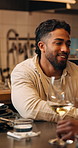 Happy, wine and man in restaurant with date for bonding, connection or romantic celebration. Smile, drinking and person with alcohol beverage for anniversary for commitment with hospitality at night.