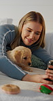 Selfie, playing and woman with puppy on bed for learning, development and bonding for adoption. Pet owner, bedroom and person with Golden Retriever dog for tech, relationship or relax for animal care