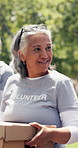 Old woman, volunteer or charity outdoor with box, conversation or donation for non profit service. Senior person, container and walk in park with NGO group, outreach support or social responsibility.