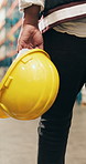 Helmet, walking and hands of man in factory for inventory, supply chain and distribution. Wholesale supervisor, manufacturing and person with ppe for shipping, logistics and delivery in warehouse