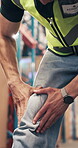 Logistics, hands and employee with knee pain, warehouse and accident at work, hurt and bone fracture. Factory, worker and person with muscle strain, flare and massage for tension relief or injury