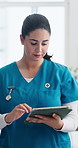 Woman, nurse and typing with tablet at clinic for healthcare report, admin or schedule for job. Person, medical professional and tech with application, checklist and smile with notes at hospital