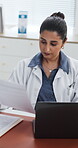 Hospital, doctor and woman with paperwork, laptop and medical research with patient history or info. Clinic, healthcare worker and person with documents for treatment plan, typing and administration