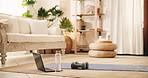 Laptop, dumbbells and water on floor of living room, fitness training gear and online workout class. Exercise mat, weights and bottle with pc to live stream in home, routine setup and tutorial video