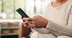 Hands, phone and texting on sofa in home with contact, scroll or notification with web chat in lounge. Person, smartphone and click with mobile app, relax and social media in living room at apartment