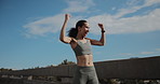 Celebration, fist pump and time with woman runner outdoor on bridge for achievement or milestone. Blue sky, exercise and watch with happy athlete cheering for fitness, running success or training