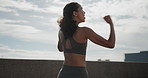 Celebration, fist pump and fitness with woman runner outdoor on bridge for achievement or milestone. Blue sky, exercise and success with happy athlete cheering for cardio, running or training goals