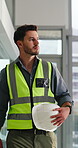 Construction, man or walk with helmet in office for building inspection, renovation project or protocol. Site, safety manager or check expansion progress for risk assessment or commercial development