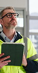 Engineer, man and walk in building with tablet, project inspection or property development compliance. Mature person, check tech and quality assurance on site for renovation, remodeling and glasses.