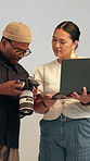 Camera, laptop and photographers in studio with review, discussion and production in collaboration. Teamwork, dslr equipment and creative employees with computer for photography project on set.
