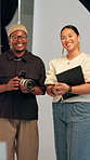 Camera, creative and face of director with photographer in studio for collaboration or shoot. Art, photography or production with man and woman on set together for bts teamwork or catalog session