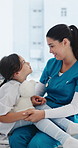 Pediatrician, girl and holding hands with comfort in hospital bed for discussion, consulting or teddy bear. People, child and doctor with counseling, support and smile for rehabilitation at clinic