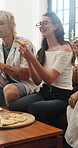 Happy, celebration or people in living room with pizza, hangout or bonding together in reunion. Social gathering, lunch or friends in house with eating, relax or shared meal in healthy relationship.