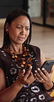 Confused, phone and surprise with woman in home living room for reaction to scammer alert. App, shock and what with mature person in apartment for communication, fake news or spam notification