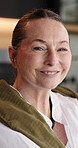 Face, home and old woman in lounge, funny and weekend break to relax, calm and smile. Apartment, pensioner and mature person on sofa, happiness and confidence in living room with morning and mindful