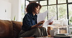 Documents, finance and stress with woman on sofa in home for budget or investment analysis. Anxirty, paperwork and thinking with person in living room apartment for debt review or financial solution