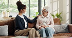 Healthcare, support or wellness with nurse and old woman on sofa in home for feedback or review. Conversation, healtcare or visit with caregiver and senior patient in apartment for assisted living