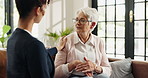 Healthcare, support or talking with nurse and old woman on sofa in home for feedback or review. Conversation, medical or wellness with caregiver and senior patient in apartment for assisted living
