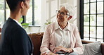 Healthcare, laughing or support with nurse and old woman on sofa in home for feedback or review. Talking, visit or wellness with caregiver and funny senior patient in apartment for assisted living