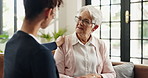Medical, support or wellness with nurse and old woman on sofa in home for feedback or review. Conversation, healthcare or visit with caregiver and senior patient in apartment for assisted living