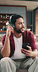 Happy, man and headphones in home with phone, streaming service and listening to music on weekend. Person, smile and audio tech in living room with rhythm, online playlist and mobile app for song.